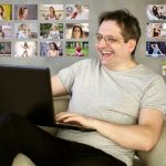 middle aged man smiling online dating on laptop