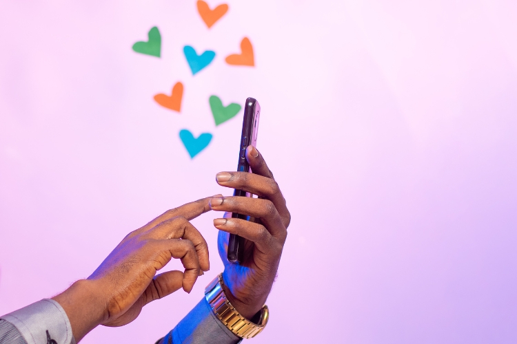 man hand sending hearts on mobile device